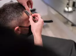 Business Fotografie eines Friseurs der einem Mann die Haare schneidet
