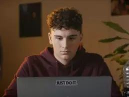 Junger Mann sitzt vor einem Laptop